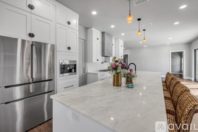 A modern kitchen with a marble countertop and stainless steel appliances.