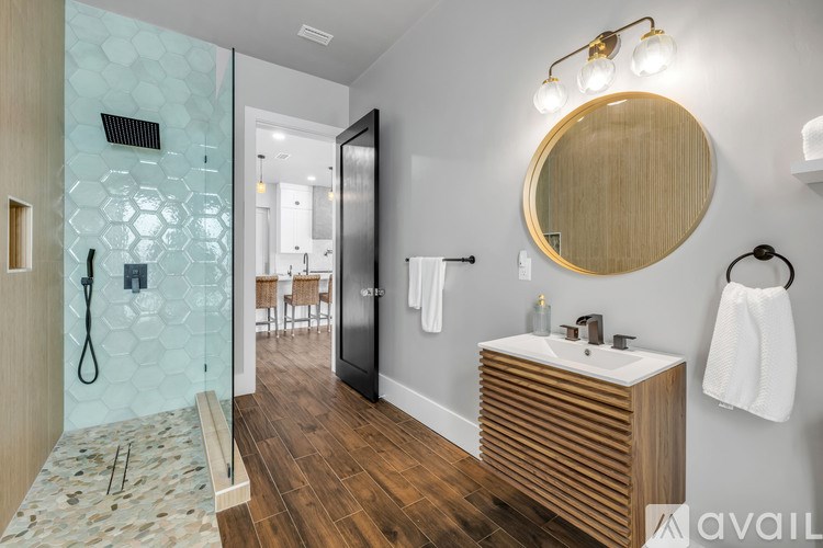 A bathroom with a wooden vanity and a glass shower.