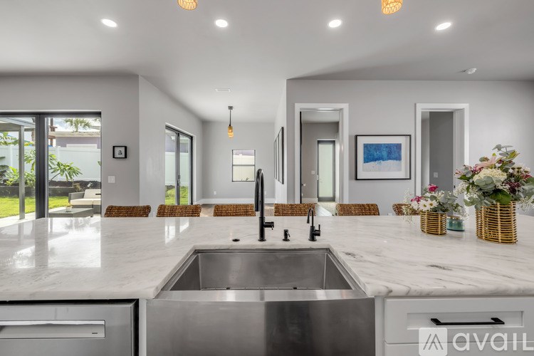 A modern kitchen with a marble countertop and stainless steel appliances.