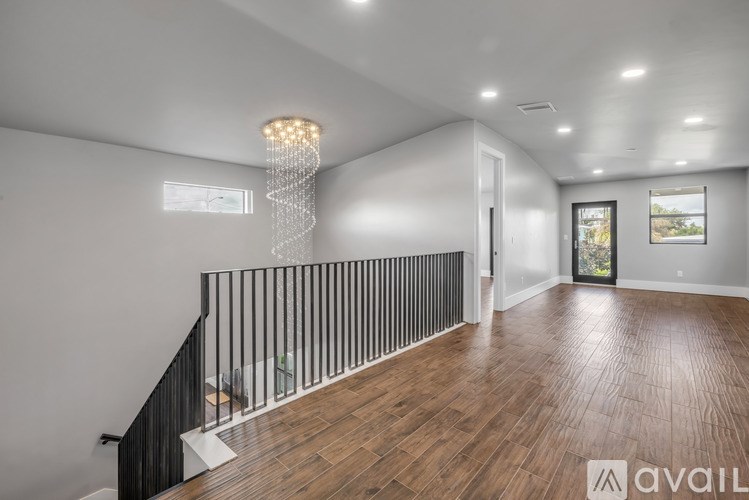 A modern interior with wooden floors and a chandelier.