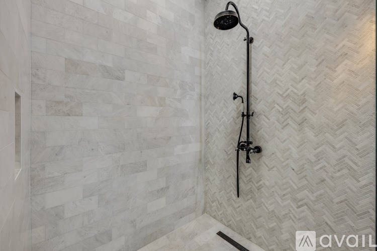 A shower with a black shower head and hand held shower.