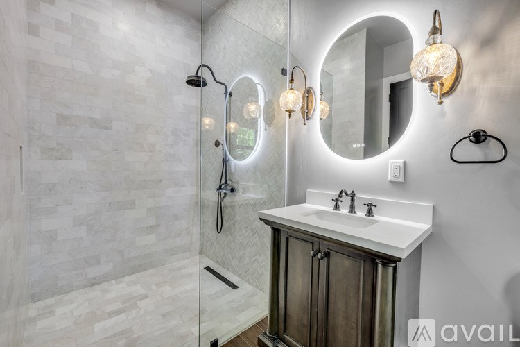 A bathroom with a white sink and a shower with a glass door.