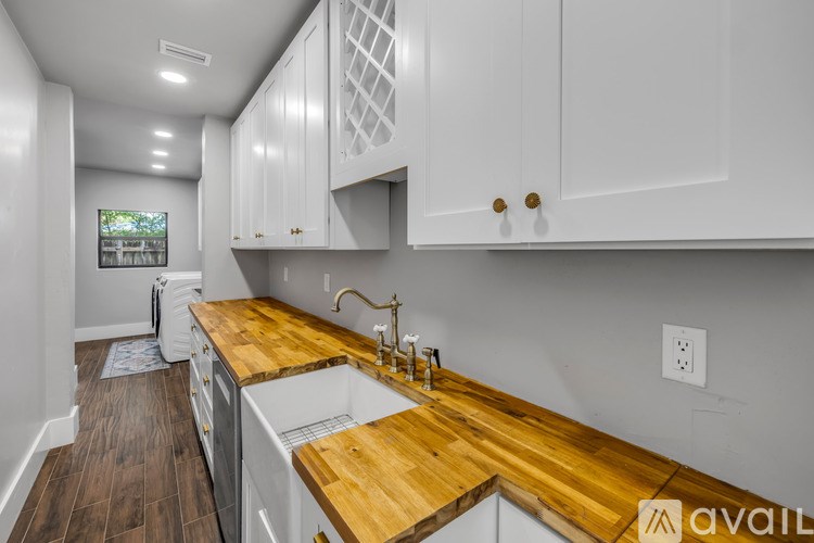 A kitchen with white cabinets and a wooden countertop.