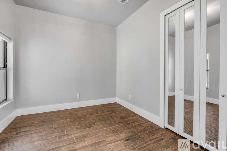 A room with a wooden floor and white walls.