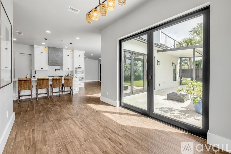 A modern kitchen with wooden floors and a dining area with chairs.