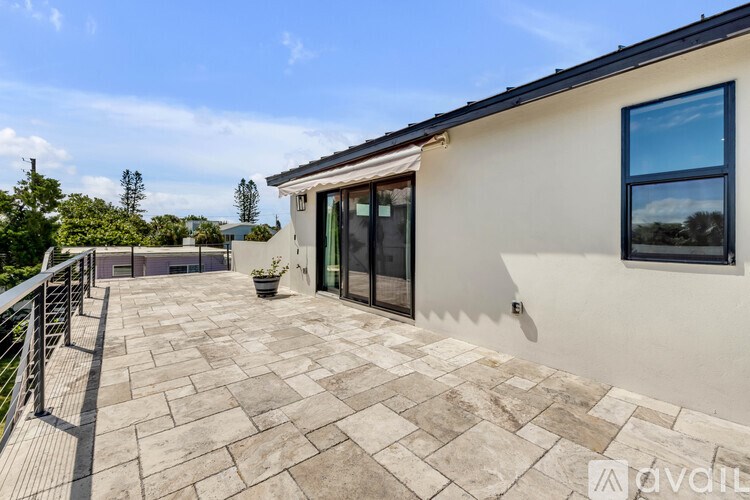 A patio area with a tiled floor and a metal railing.