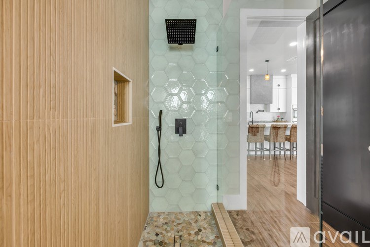 A bathroom with a glass shower door and a wooden wall.