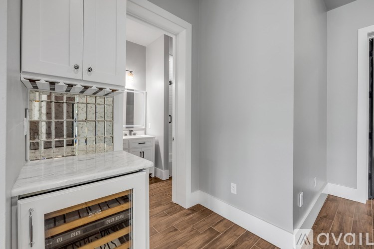 A kitchen with white cabinets and a marble countertop.