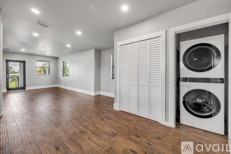 A laundry room with a washer and dryer, and a wooden floor.