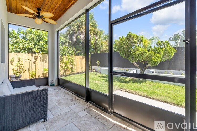 A patio with a ceiling fan and sliding glass doors.