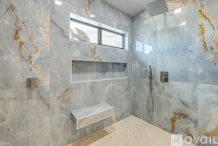A bathroom with marble walls and a window.