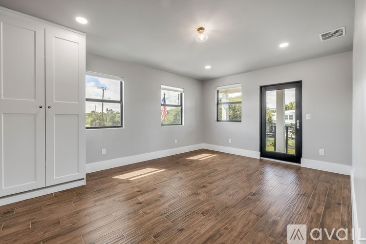 A spacious room with wooden floors and white walls.