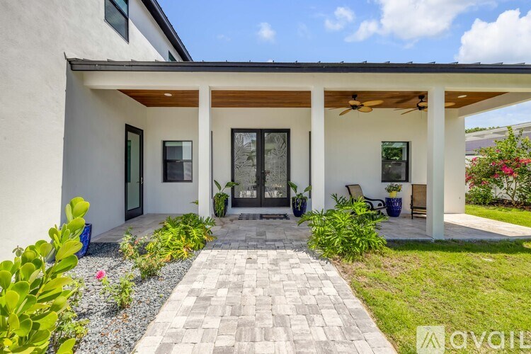 A modern house with a covered patio and a walkway leading to the entrance.