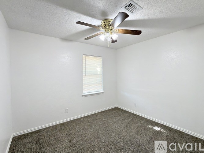 A room with a ceiling fan and a window.
