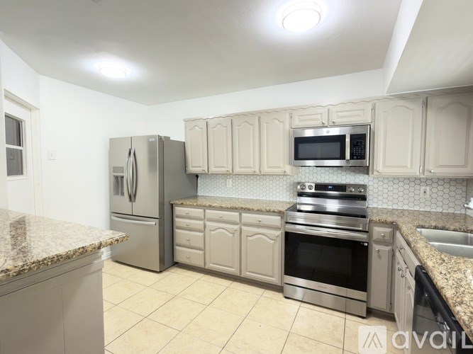 A kitchen with a granite counter top and stainless steel appliances.