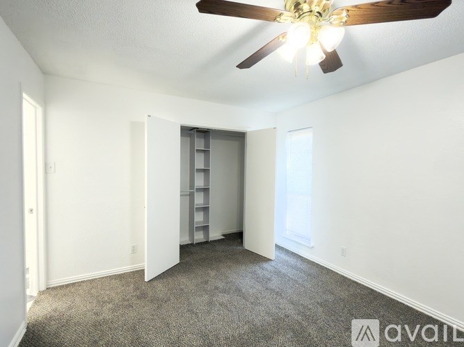 A room with a ceiling fan and a carpeted floor.