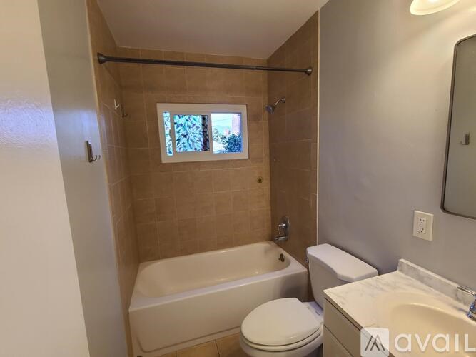 A bathroom with a tub, toilet, and sink.