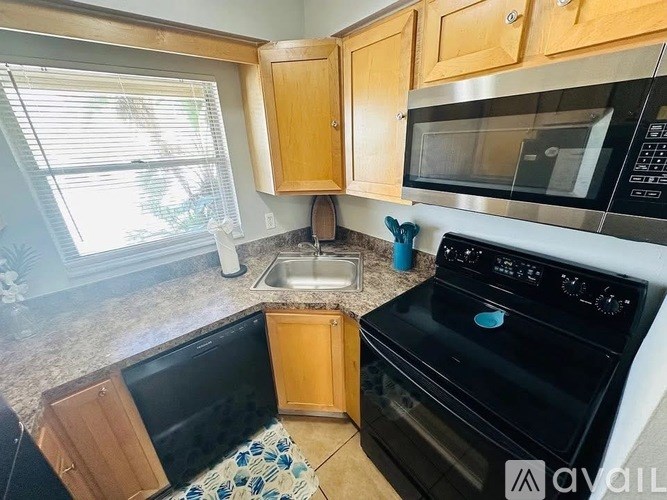 A kitchen with a black oven and wooden cabinets.