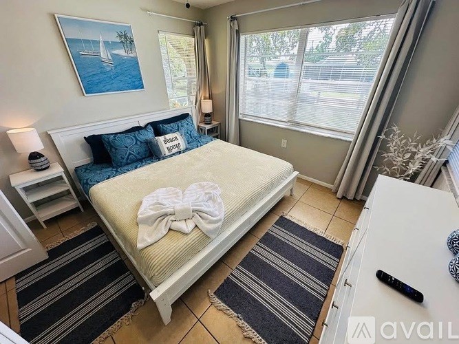 A bedroom with a bed, nightstand, and window.