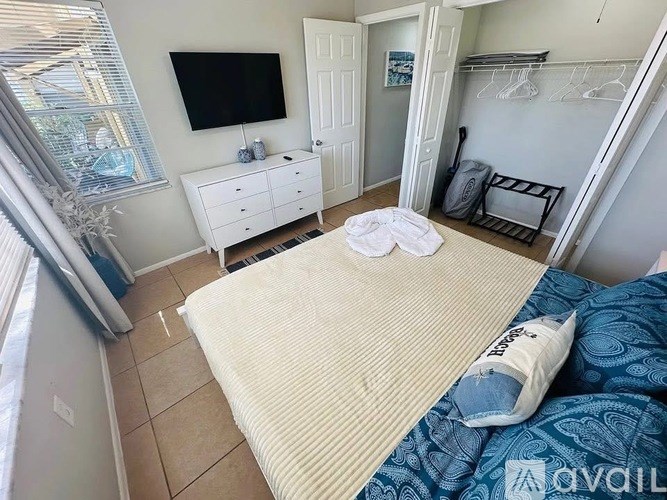 A bedroom with a bed, dresser, and television.