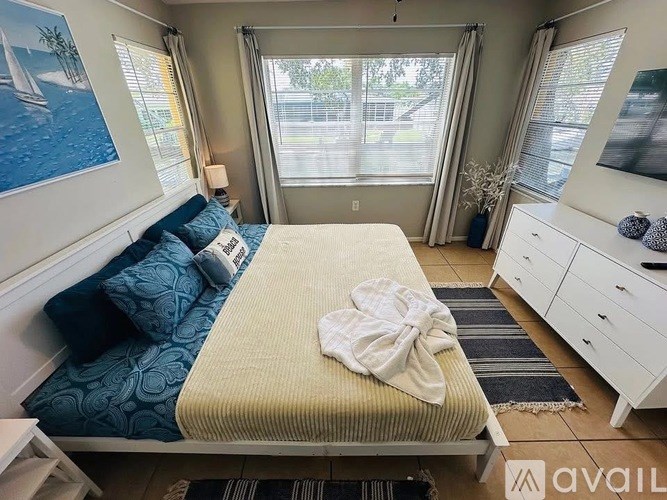 A bedroom with a bed, dresser, and window.