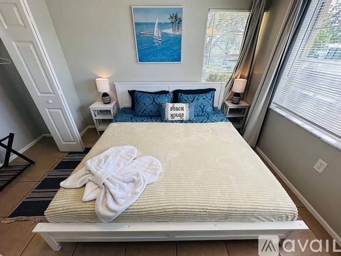 A bedroom with a bed, a nightstand, and a painting on the wall.