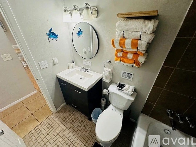 A bathroom with a toilet, sink, and towel rack.