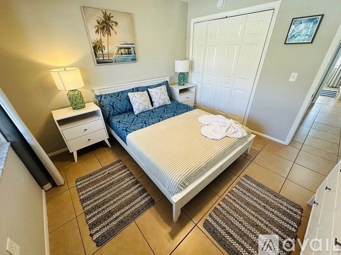 A bedroom with a bed, nightstand, and lamp.