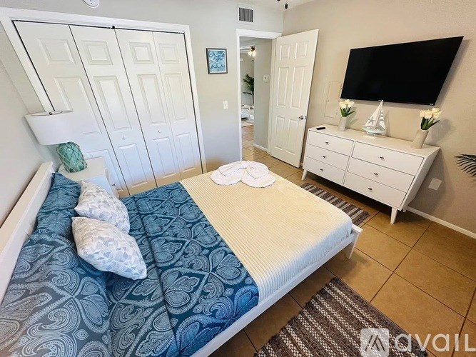 A bedroom with a bed, dresser, and mirror.