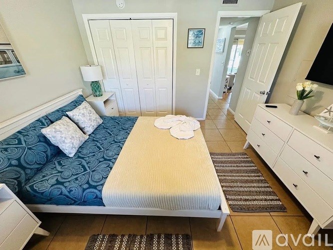 A bedroom with a bed, dresser, and mirror.