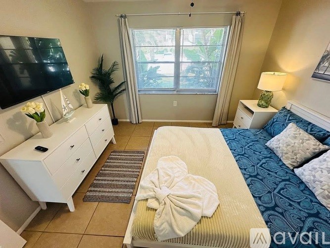 A bedroom with a bed, dresser, and window.