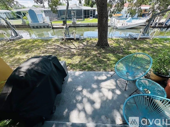 A patio with a table, chairs and a tree.