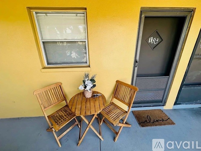 A wooden table and chairs are set up on a porch.