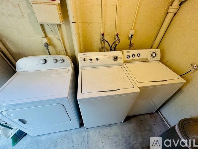 A white washing machine and dryer are sitting next to each other.