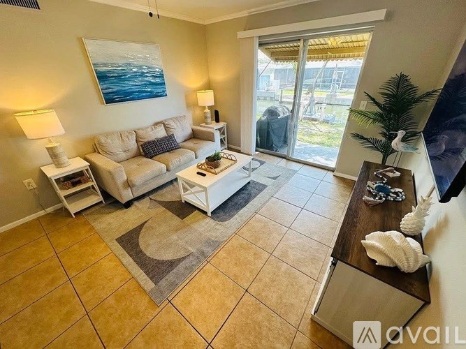 A living room with a sofa, a table, and a painting on the wall.