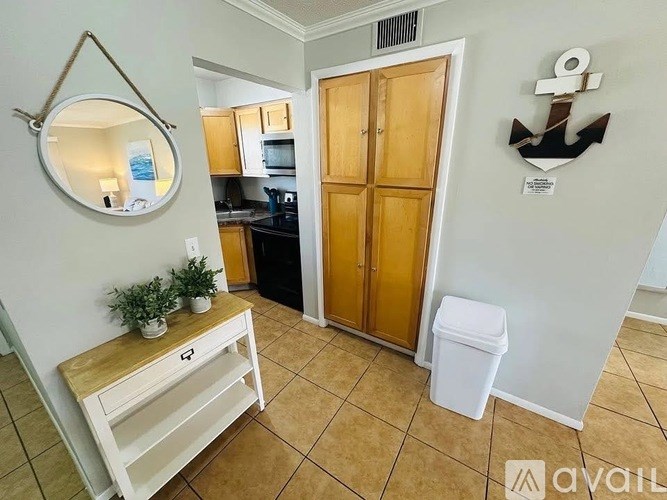 A kitchen with a white countertop and a white trash can.