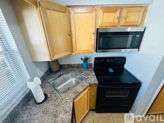 A kitchen with wooden cabinets and a black oven.