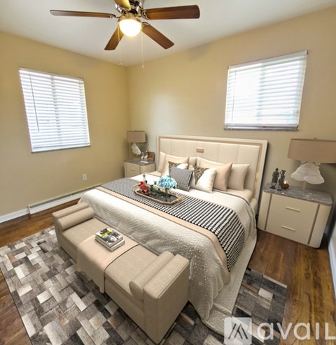 A bedroom with a large bed and a ceiling fan.