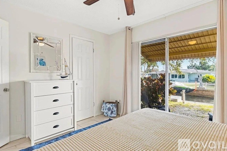 A bedroom with a bed, dresser, and mirror.