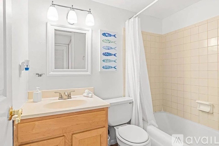 A bathroom with a toilet, sink, and shower curtain.