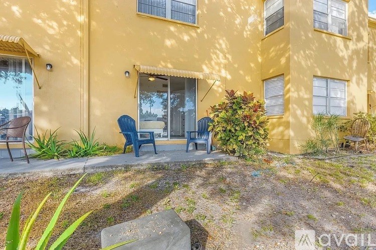 A yellow building with a patio and chairs.