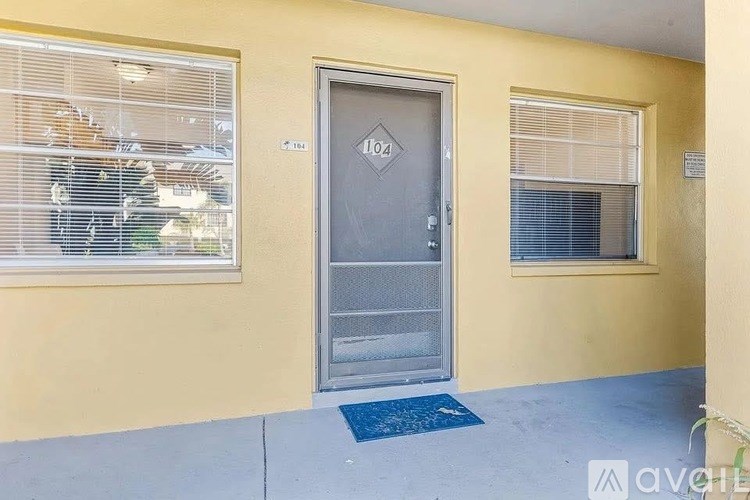 A yellow building with a grey door and window.