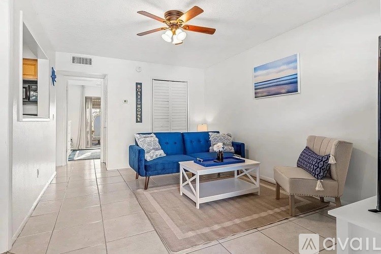 A living room with a blue couch and a ceiling fan.