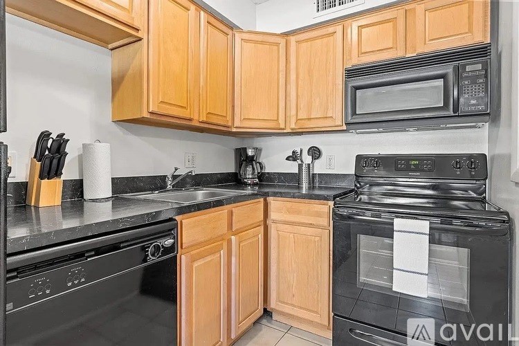 A kitchen with wooden cabinets and black appliances.