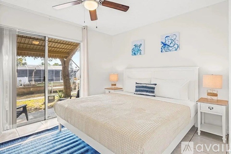 A bedroom with a large bed and a ceiling fan.
