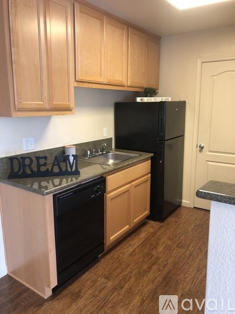 A kitchen with wooden cabinets and black appliances.