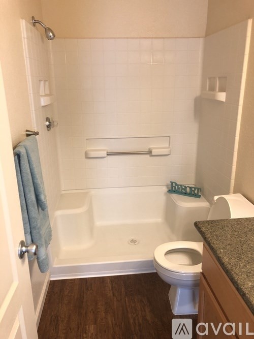 A bathroom with a toilet, tub, and towel.