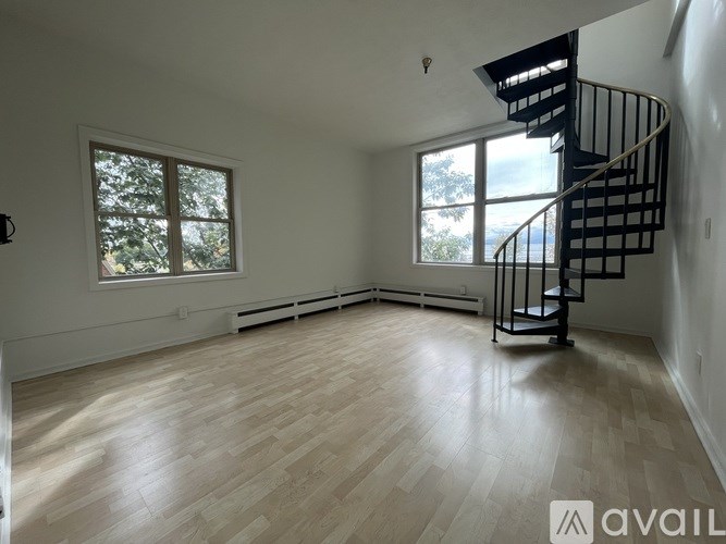 A room with a spiral staircase and a window.