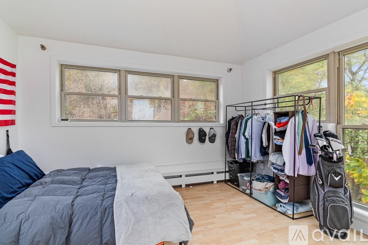 A room with a large window and a door is available for rent.