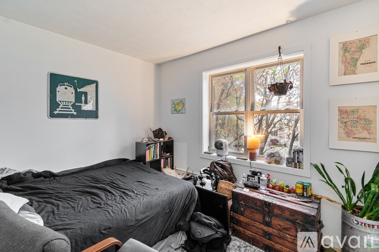 A room with a bed, a window, and a few pictures on the wall.